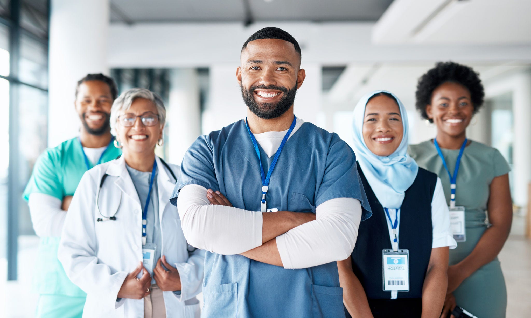 A diverse group of health care professionals smiling and facing the camera.