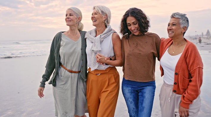 Four women walk on the beach