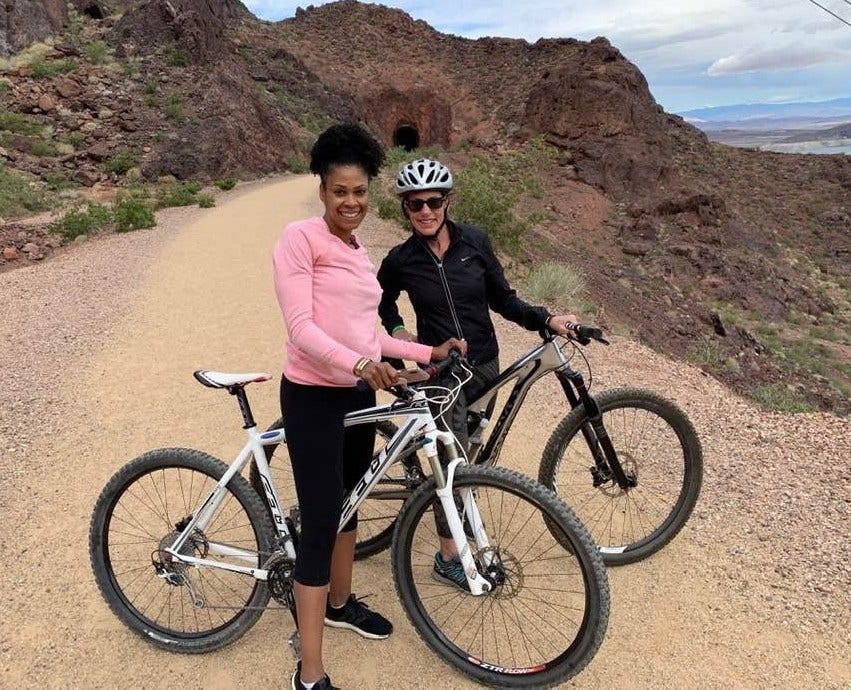 Two women riding bicycles on a trail