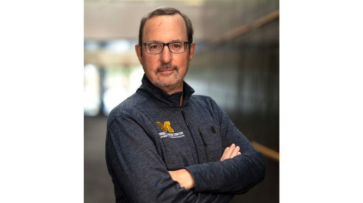 Dr. Steven Katz, MD, MPH stands for a photo wearing a University of Michigan quarter-zip sweater
