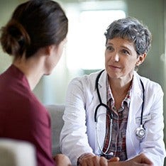 A female doctor comforts her patient