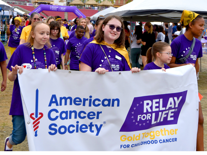 Group of kids holding American Cancer Society event banner.