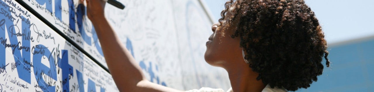 woman signing ACS CAN advocacy banner