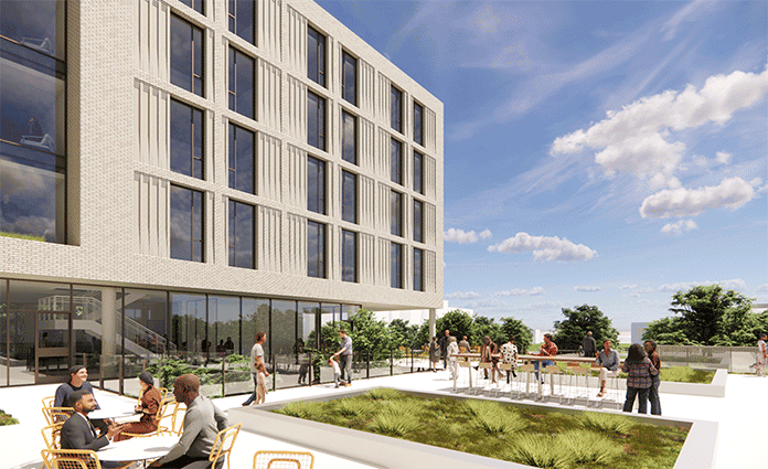 People sitting and walking outside modern building with courtyard.