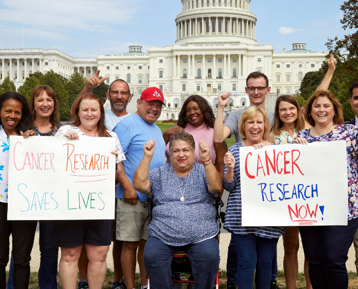 many people gathered in front of capital holding signs