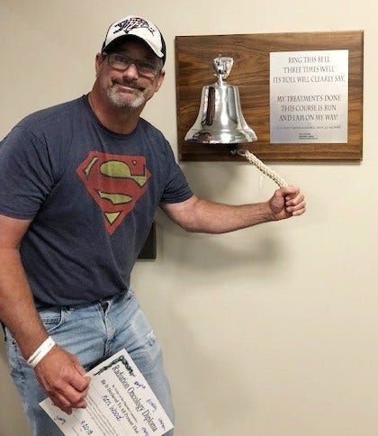Cancer survivor, Ken Wood rings bell indicating he is cancer free