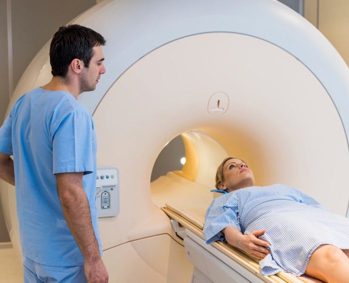 a tech readies a patient for an mri scan