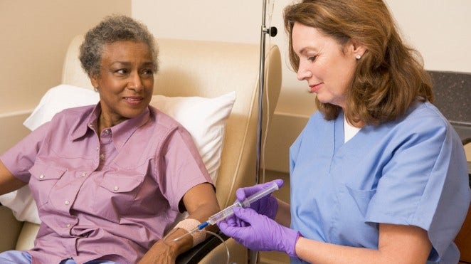 nurse administers chemo to woman