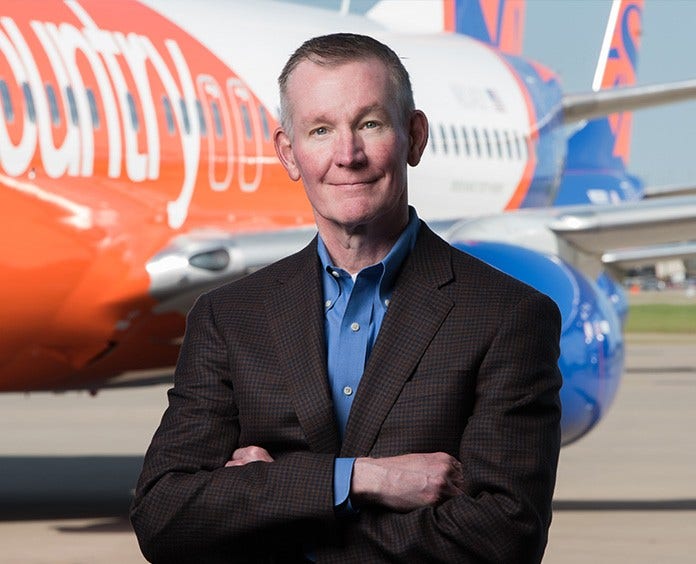 Jeff Mader posing hands crossed in front of an airplane