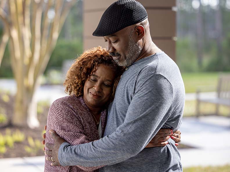 A couple holds each other while smiling in relief