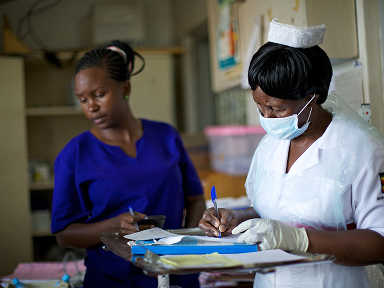Two healthcare workers review documents together in a clinical setting.