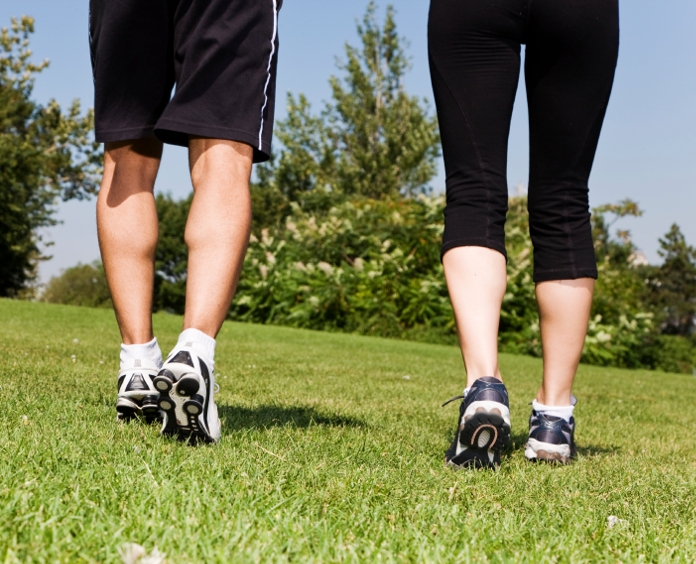 close up of a man and woman's legs as they walk outside