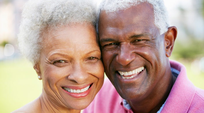 a happy African American couple with heads together