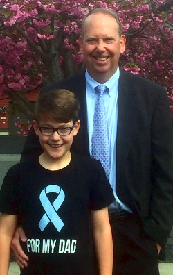 prostate cancer survivor, Brian Glennon standing outside with his son