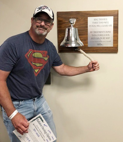 Cancer survivor, Ken Wood rings bell indicating he is cancer free