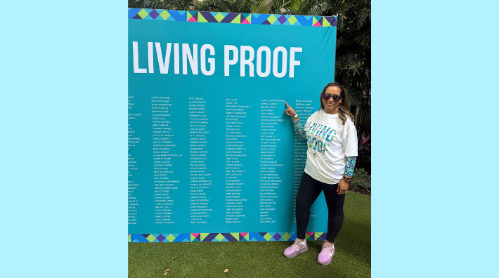 Avi Grant, cancer survivor, points to her name on a living proof sign