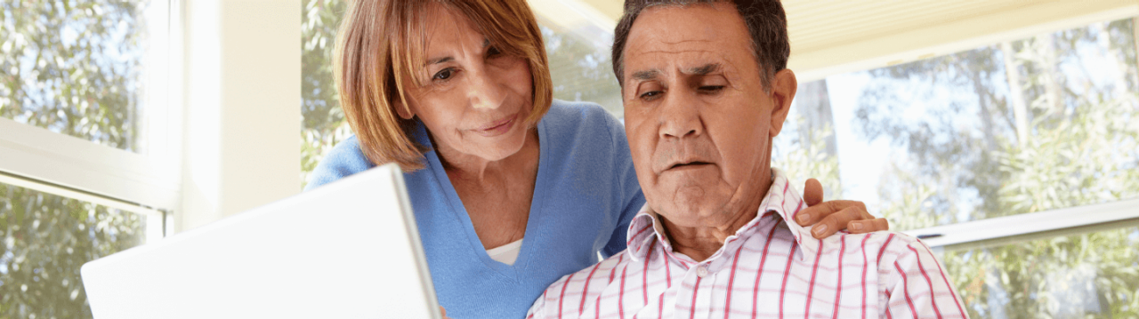 An older couple looking at a laptop together