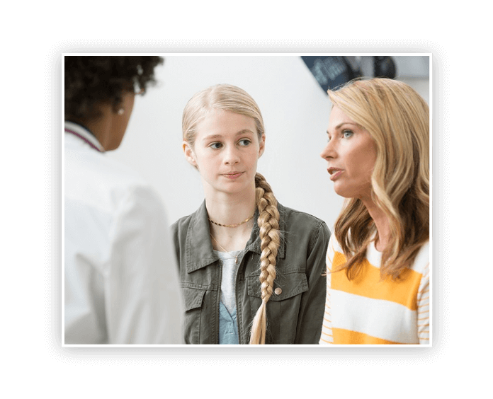 caucasian mother and daughter talking to doctor