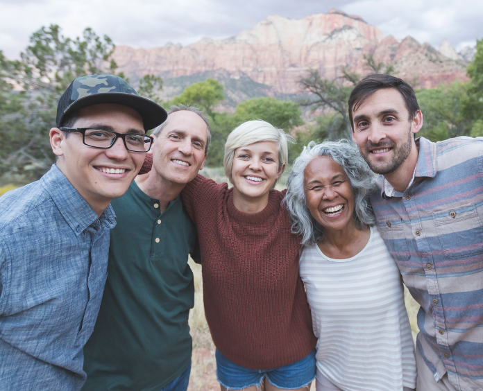 Five people smiling with mountains in the background