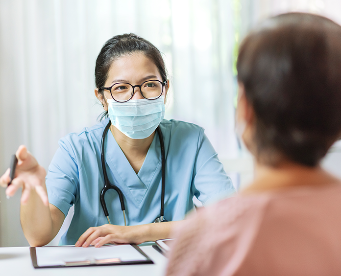 Doctor in a surgical mask talking to a patient