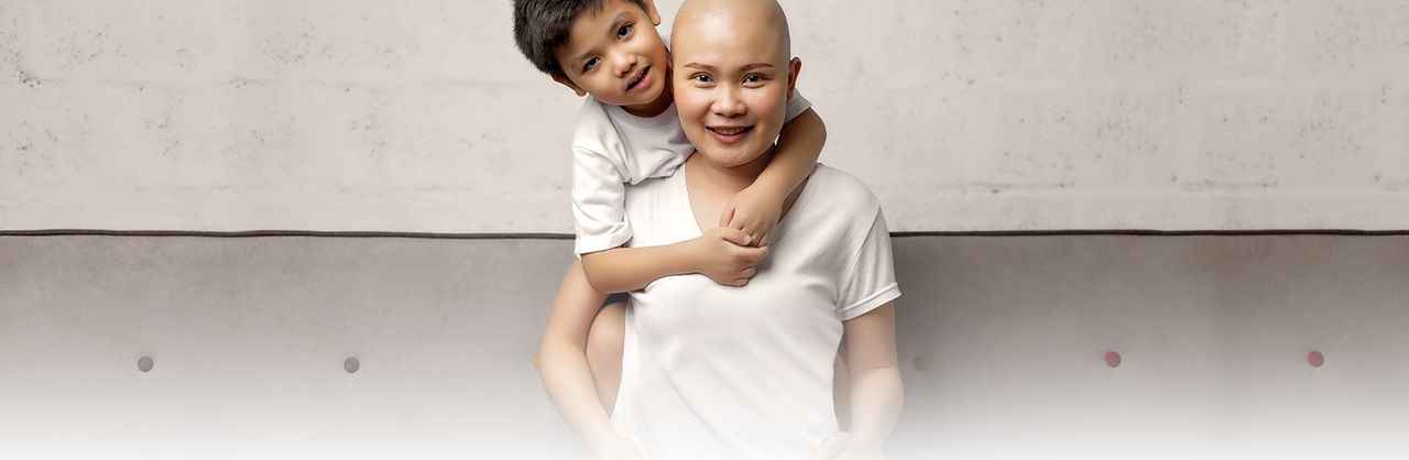 Asian son with arms around mother