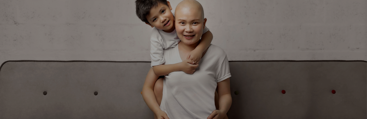 Young Asian boy hugging Asian woman with bald head