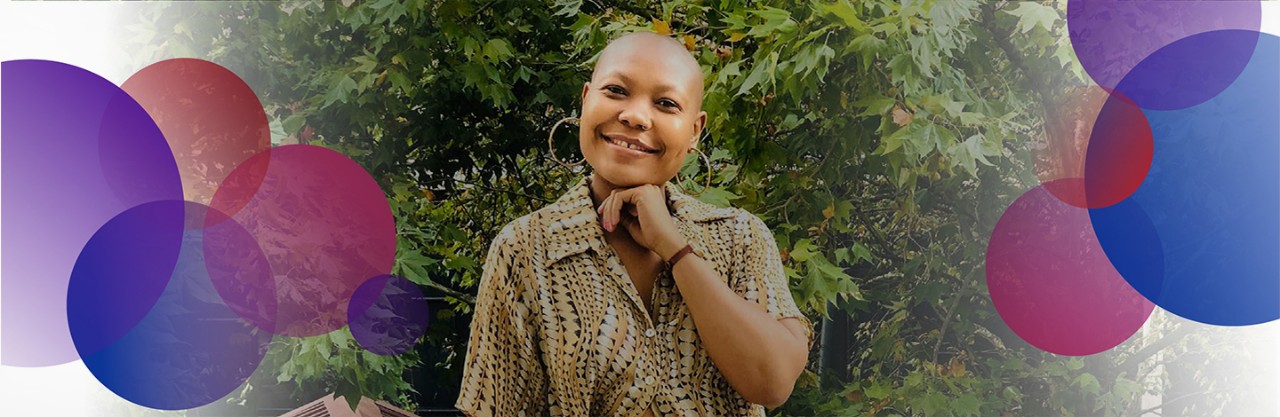 bald black woman wearing large earrings and patterned shirt