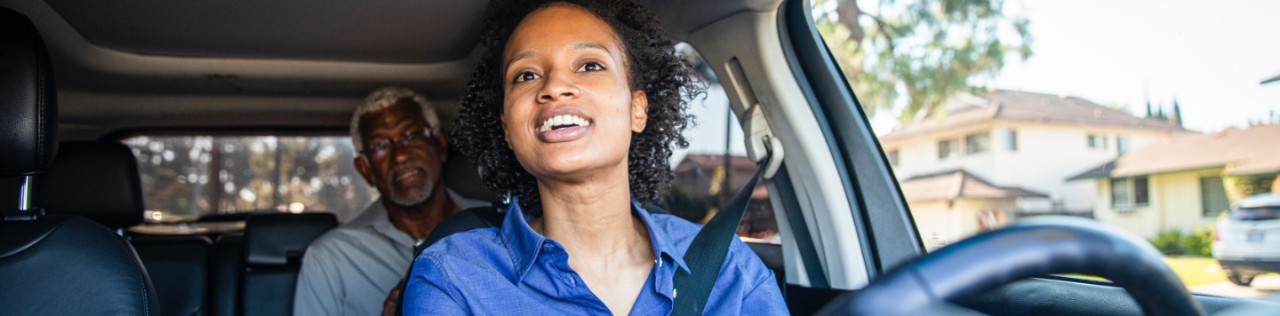 black female driver driving black male passenger in the backseat