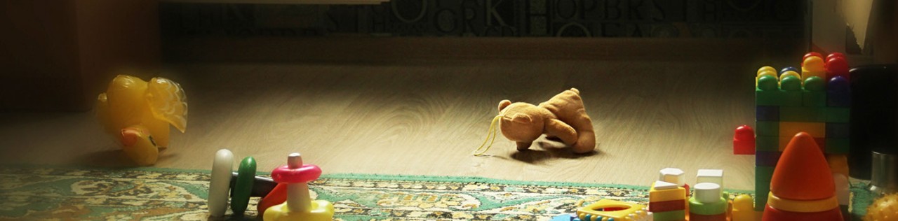 Many toys lying on the floor in a dark room