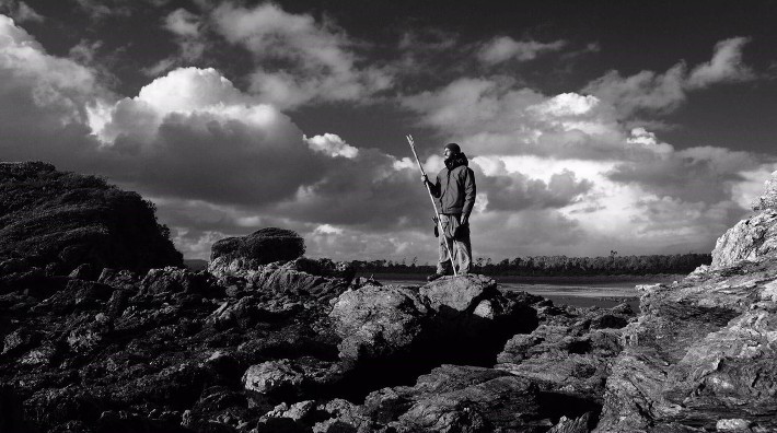 black and white landscape of Luke Soderling standing on rocky mountain
