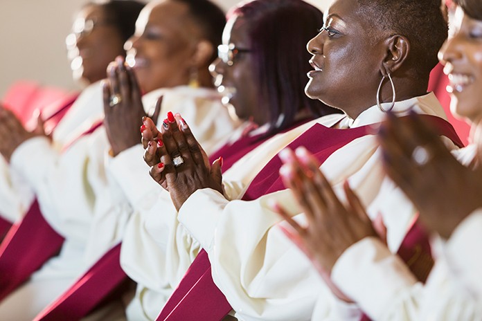 side view of Black women in red choir robes clapping