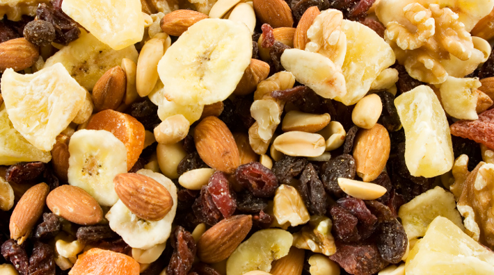 close up of trail mix ingredients including nuts, raisins, banana chips and cranberries