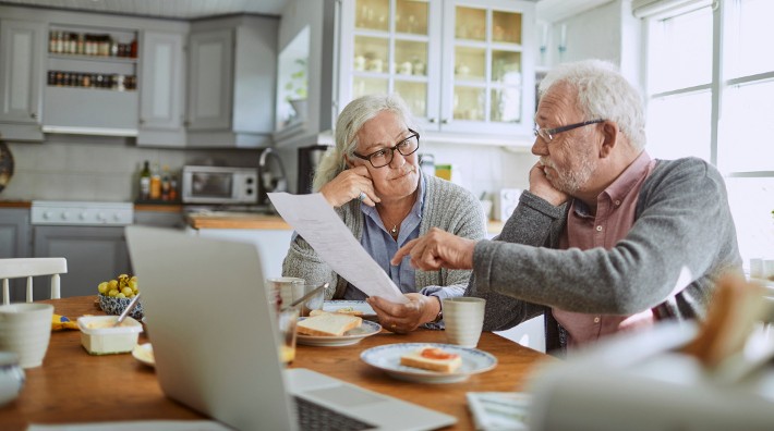 senior couple doing bills at their kitchen table