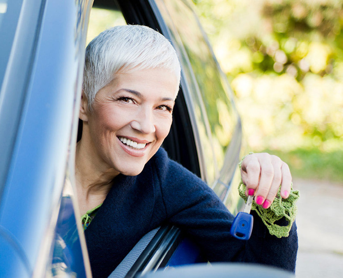 woman in car leaning out the window holding keys