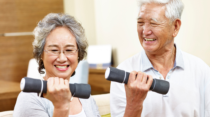 happy senior Asian couple lift hand weights