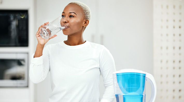Woman Wearing White Shirt Drinks Water