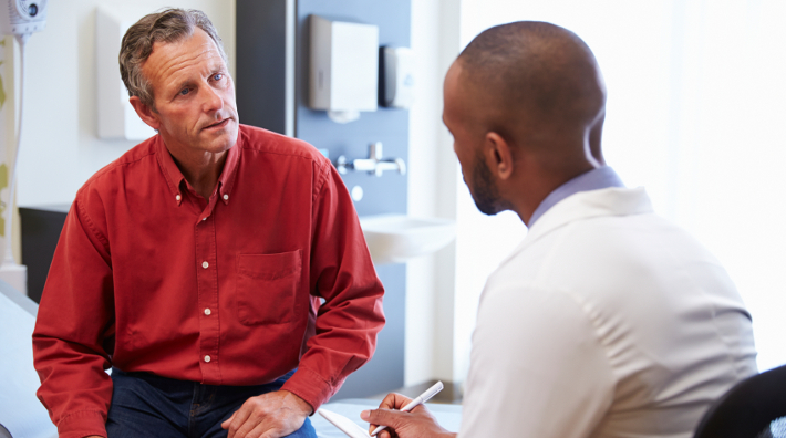 man talks to his doctor in office