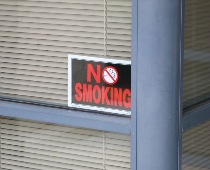 no smoking sign in the window of a business