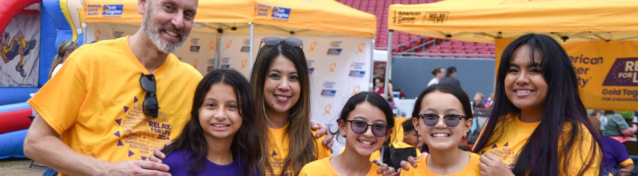 group of people all wearing gold shirts while flexing muscles at a Gold Together event