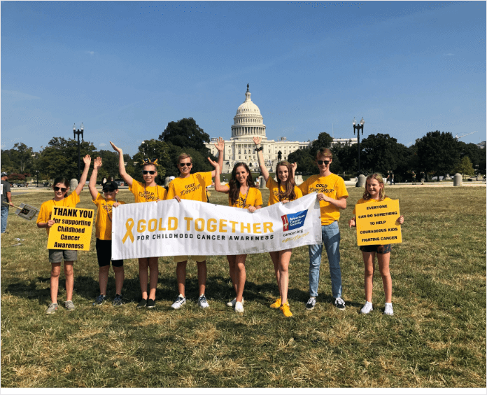 group of white youth holding Gold Together banner outside Capital building