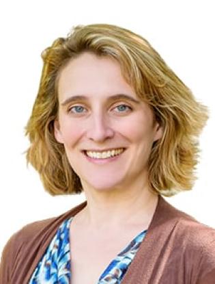 woman with reddish blonde chin-length hair, blue eyes, wearing blue printed blouse under rust sweater