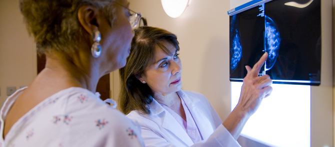 doctor goes over mammogram results with patient in exam room