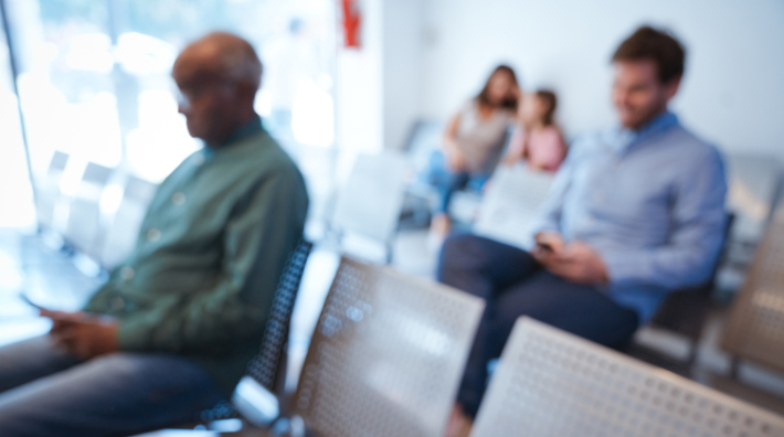out of focus image of people sitting in a doctor's waiting room