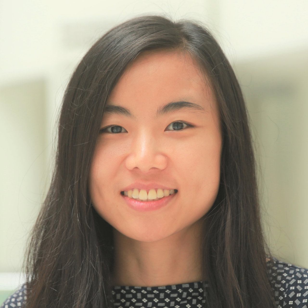 Asian woman with fluffy brown hair, white scoop neck top
