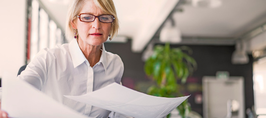 woman sorting through paperwork at office desk